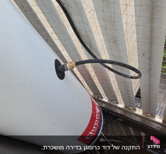 דוד שמש מותקן ליד גדר עם צינור מחובר